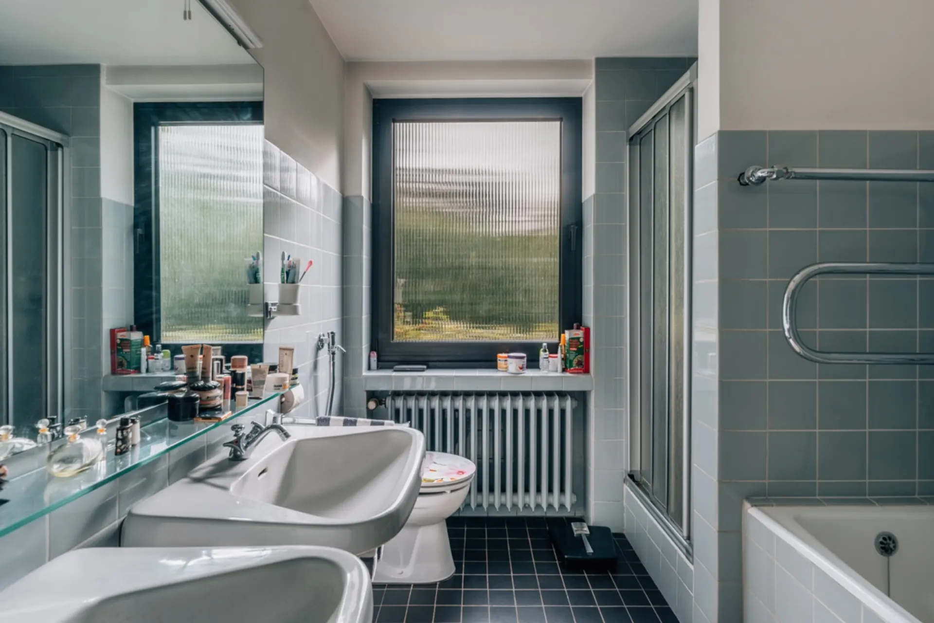 Modernes Badezimmer mit zwei Waschbecken, Badewanne, Toilette und großem Fenster.