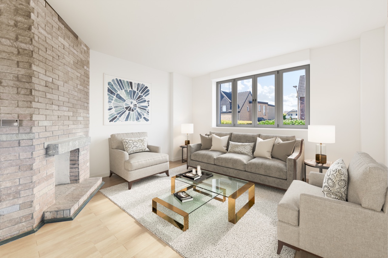 Helles Wohnzimmer mit Sofa, zwei Sesseln, Kamin, Glastisch und großem Fenster.