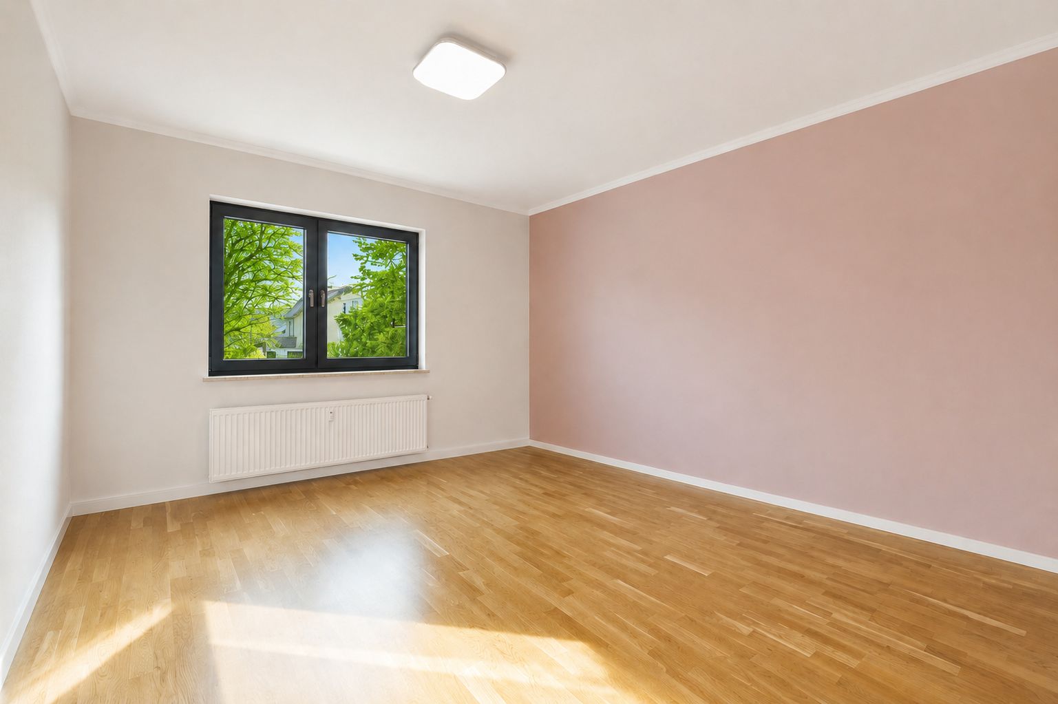 Leeres Zimmer mit Holzfußboden, großem Fenster und rosa Wand.