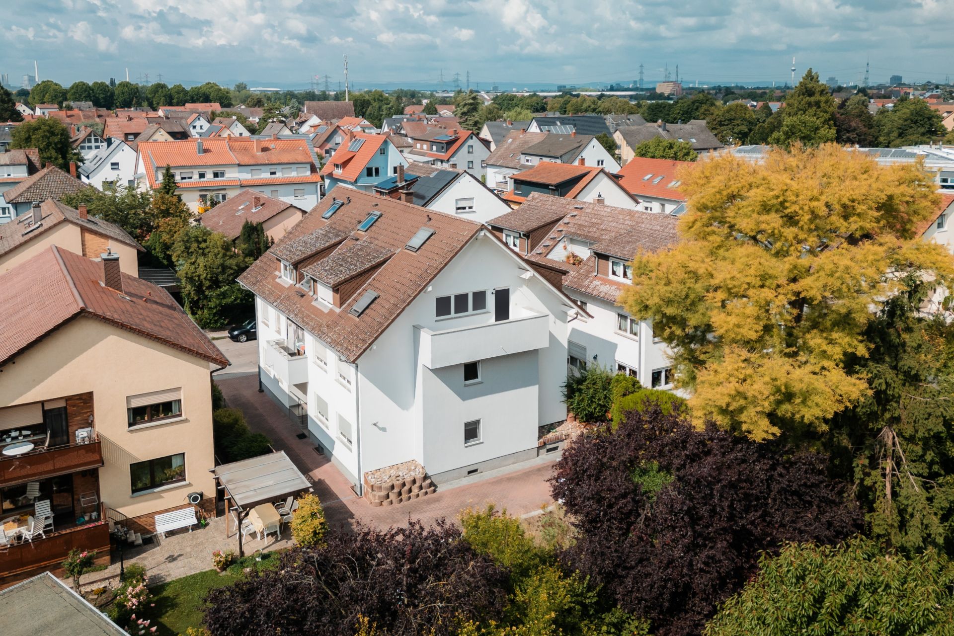 Luftaufnahme von Wohnhäusern mit roten Dächern und Bäumen in einer ruhigen Nachbarschaft.