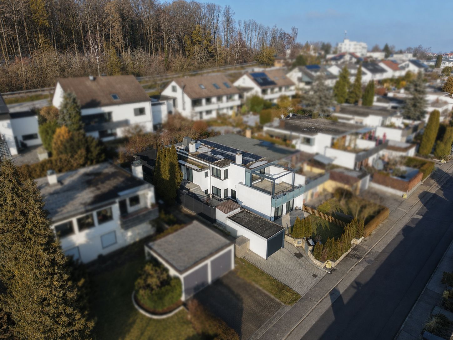 Luftaufnahme eines modernen Wohnhauses mit Garage in einer ruhigen Wohngegend.