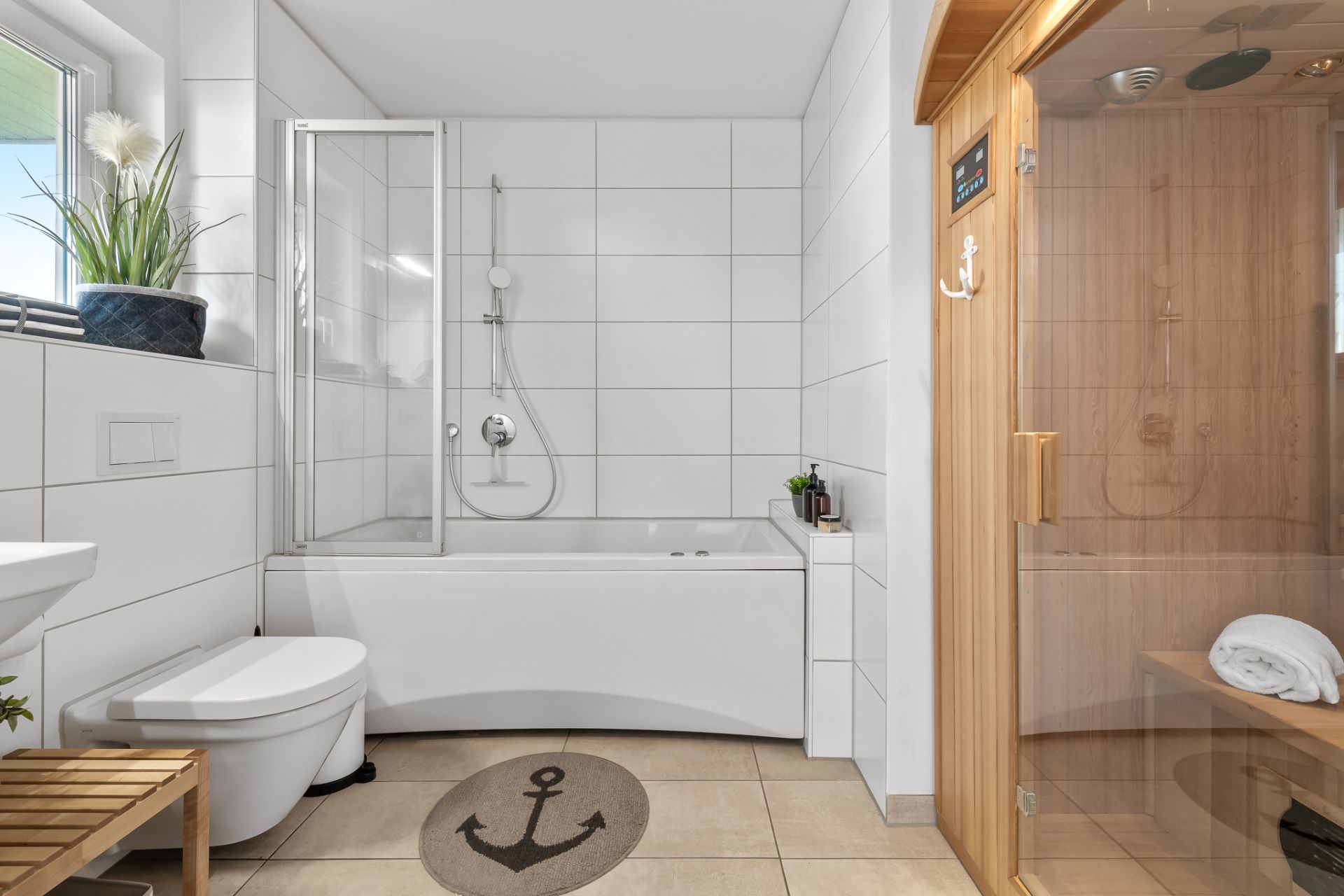Modernes Badezimmer mit Badewanne, Toilette, Holzsauna und Fenster.