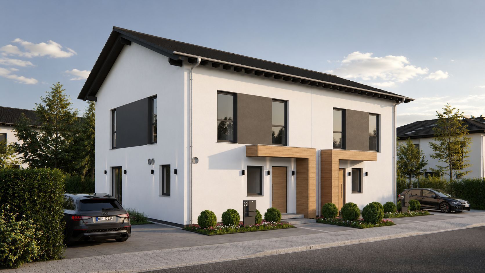 Doppelhaushälfte mit weißer Fassade, großen Fenstern und zwei Eingängen, davor geparkte Autos.