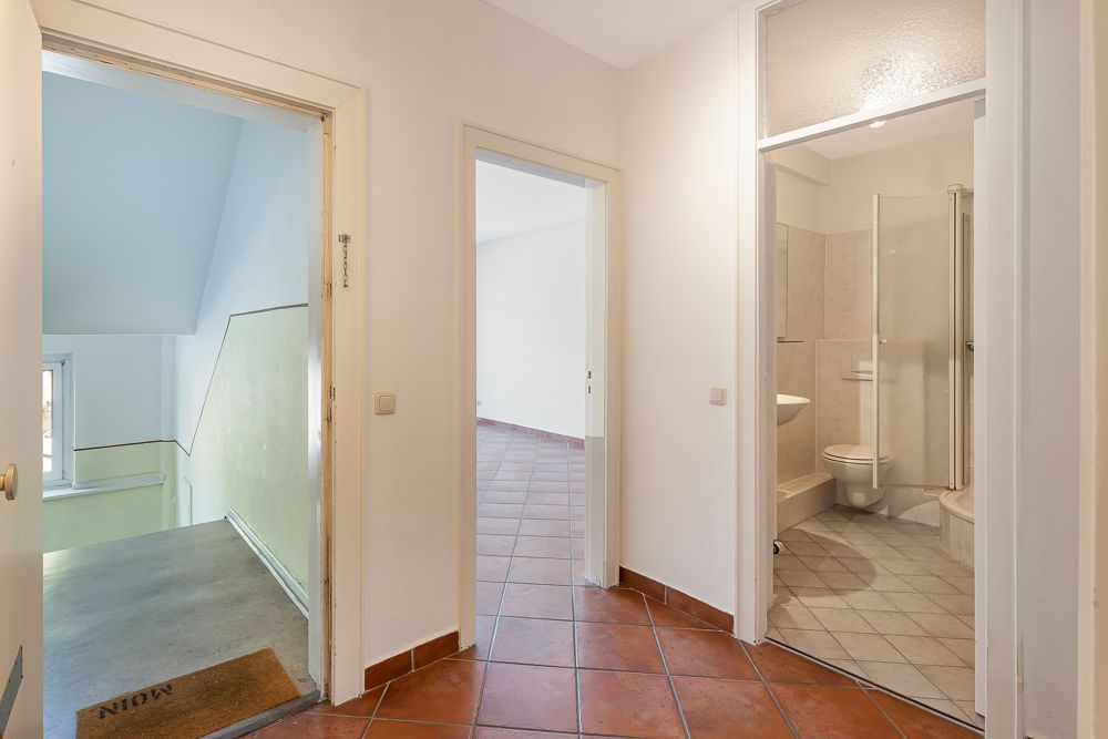 Heller Flur mit Zugang zum Badezimmer, zu einem Zimmer und zum Treppenhaus.