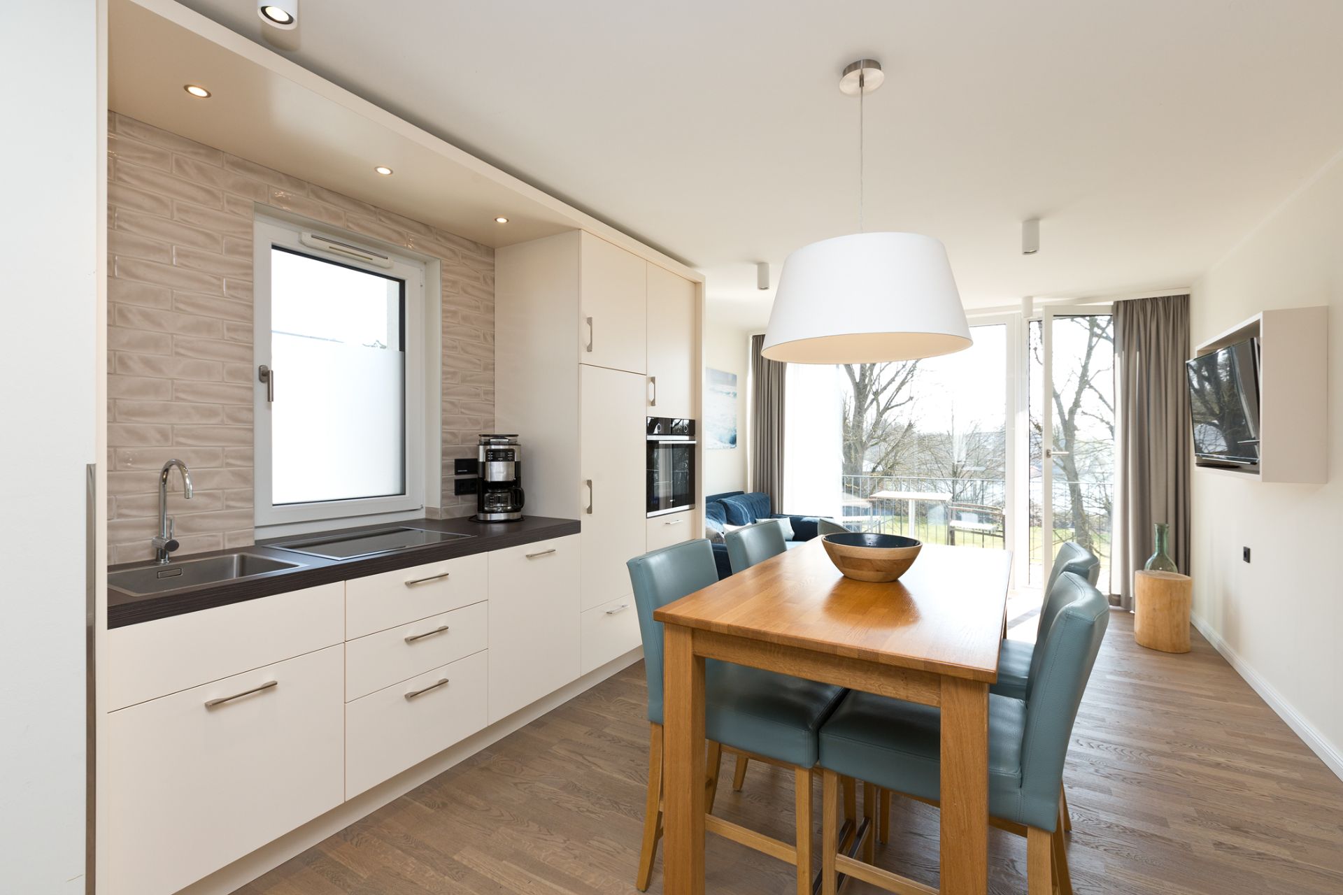 Helle Küche mit Esstisch, sechs Stühlen und Zugang zum Balkon, modernes Design.