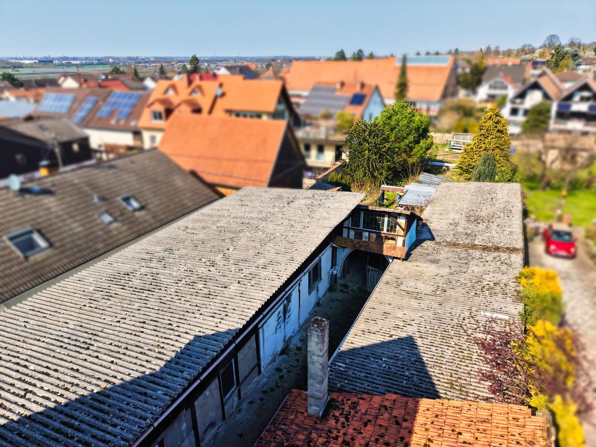 Blick auf mehrere Wohnhäuser mit Ziegeldächern und einem Innenhof.