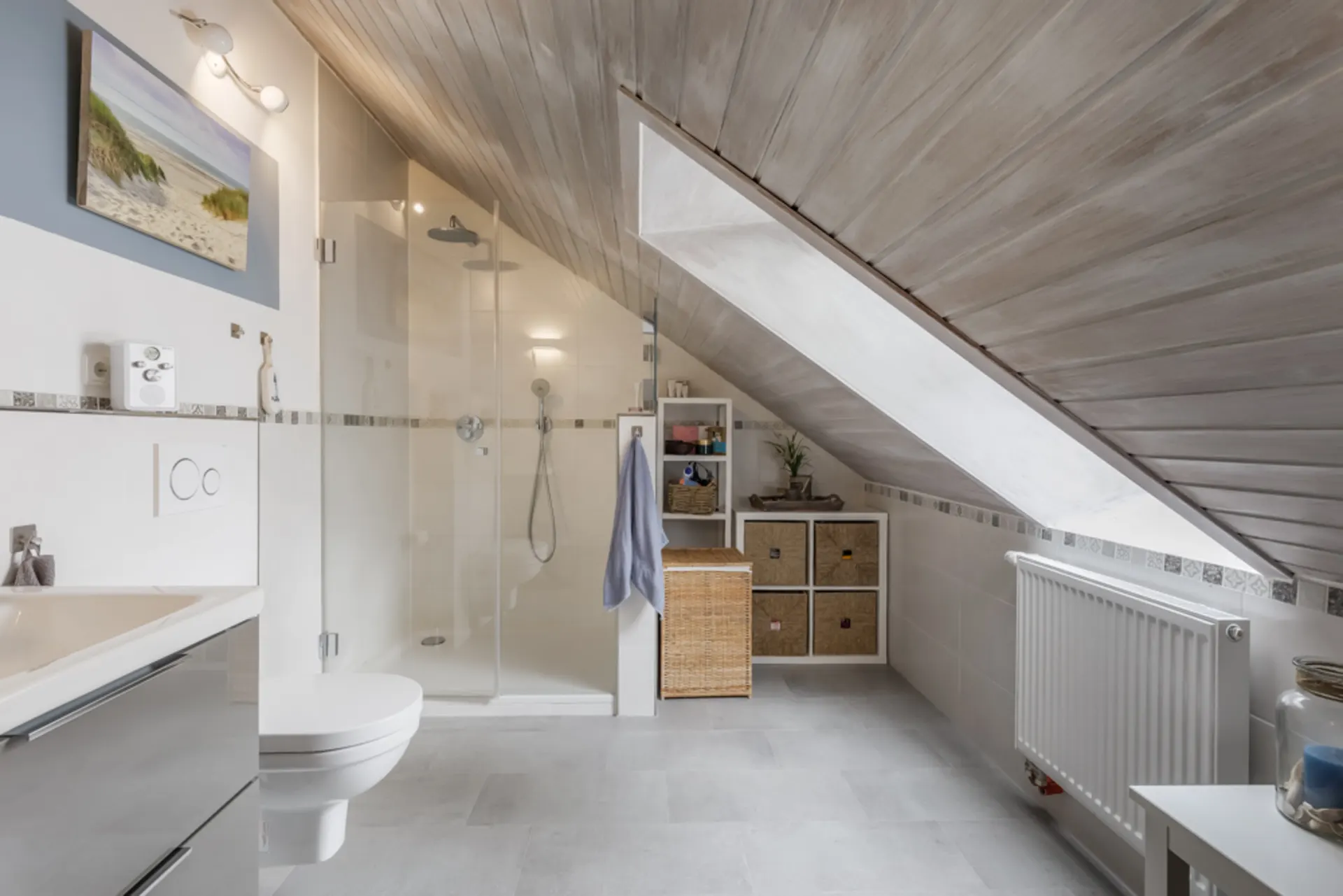 Modernes Badezimmer mit Dachschräge, Dusche, WC, Waschbecken und Regalen.