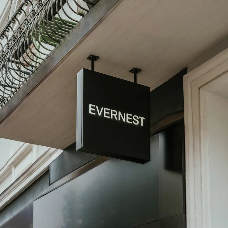 Schwarzes Schild mit weißer Aufschrift EVERNEST an einem Gebäude.