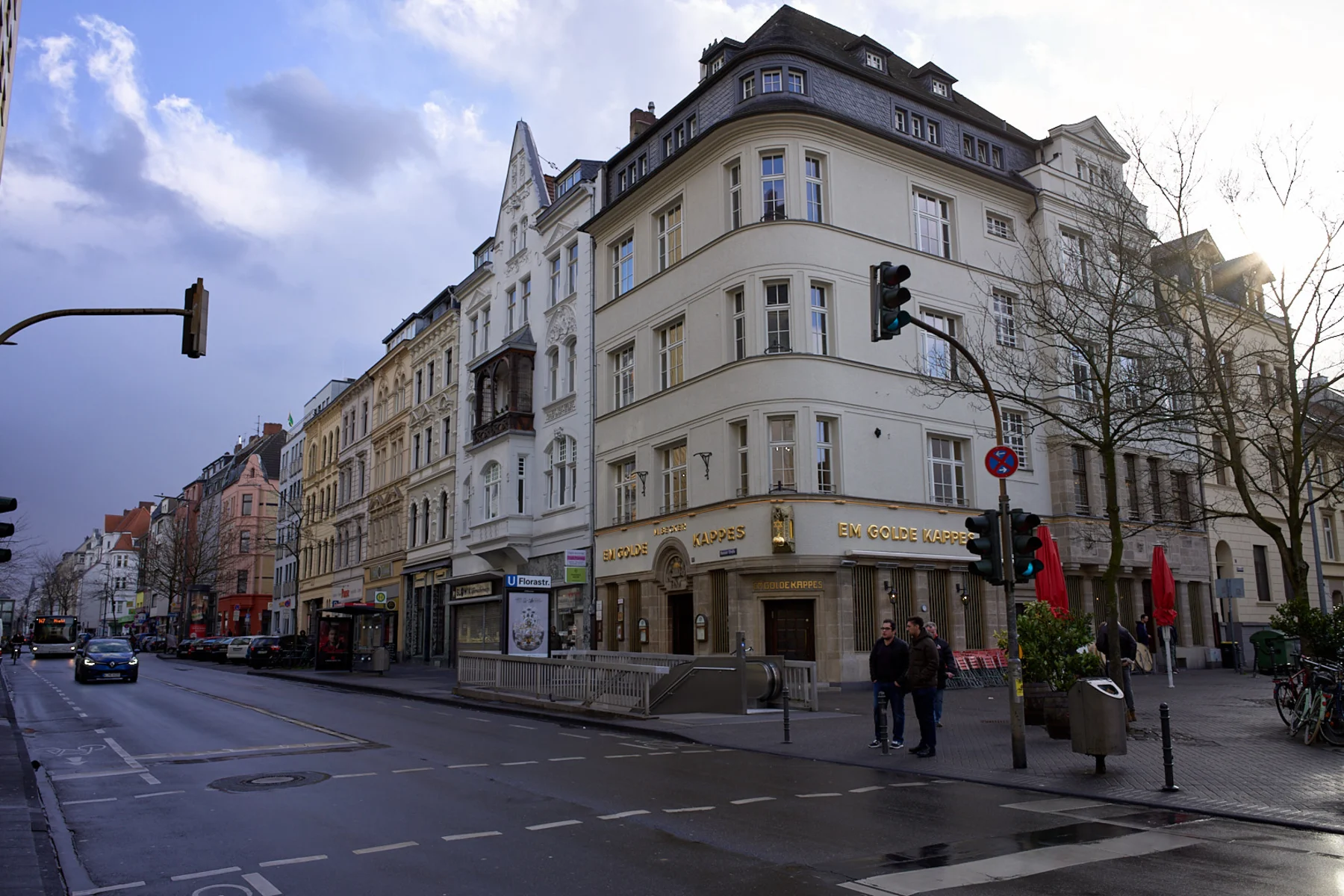 Mehrstöckige Wohnhäuser an einer Straßenecke mit U-Bahn-Eingang und Ampel.