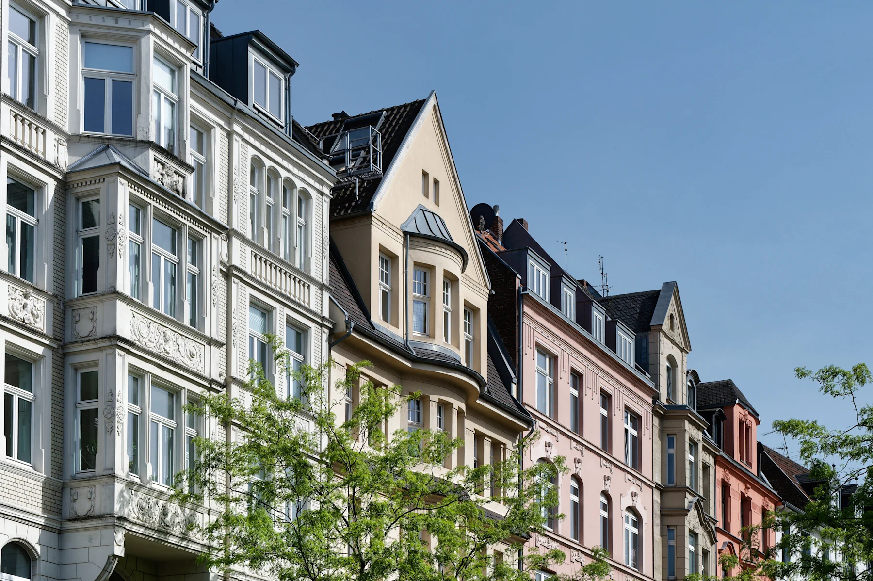 Mehrstöckige Wohnhäuser an einer Straßenecke mit U-Bahn-Eingang und Ampel.