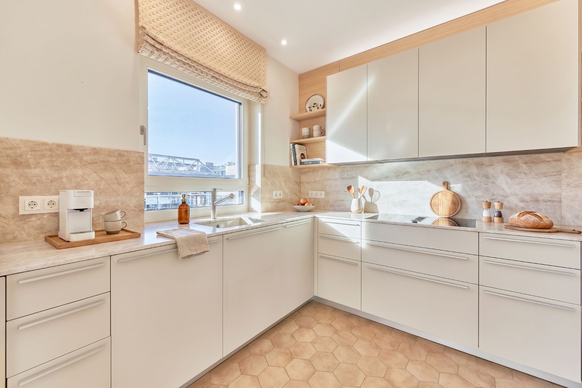 Helle, moderne Einbauküche mit weißen Schränken, Fenster und Arbeitsplatte.