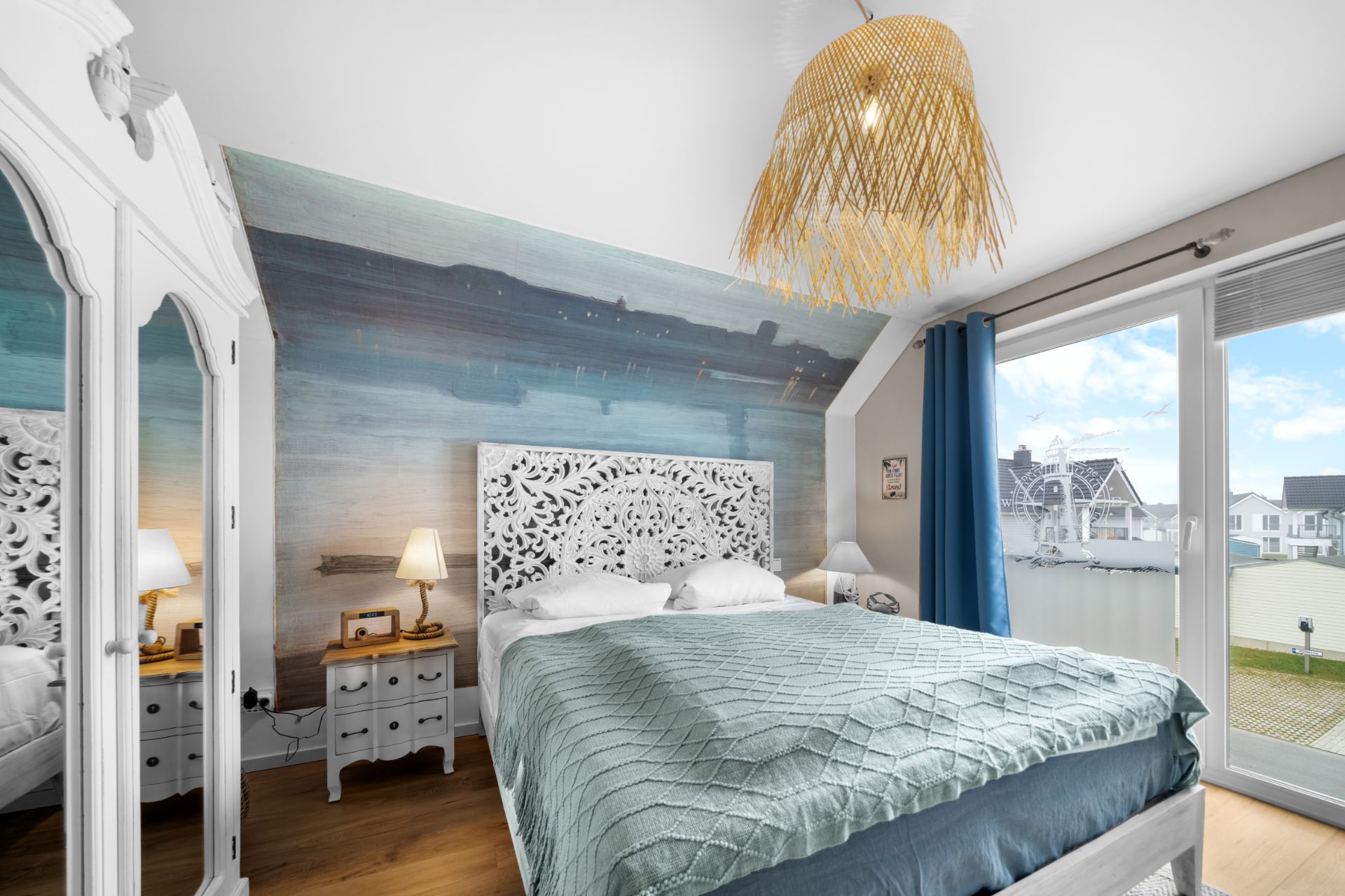 Helles Schlafzimmer mit Doppelbett, gemusterter Wand, großem Fenster und Balkonzugang.
