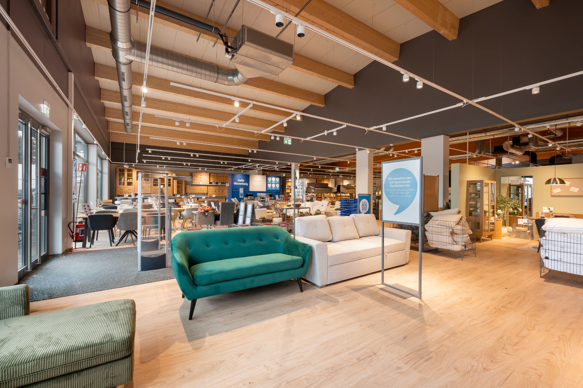 Innenraum eines Möbelausstellungsraums mit Sofas, Stühlen und Tischen auf Holzfußboden.