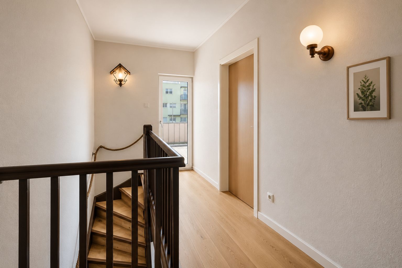 Heller Flur mit Holztreppe, Holzboden, Wandlampen und einem Fenster am Ende.