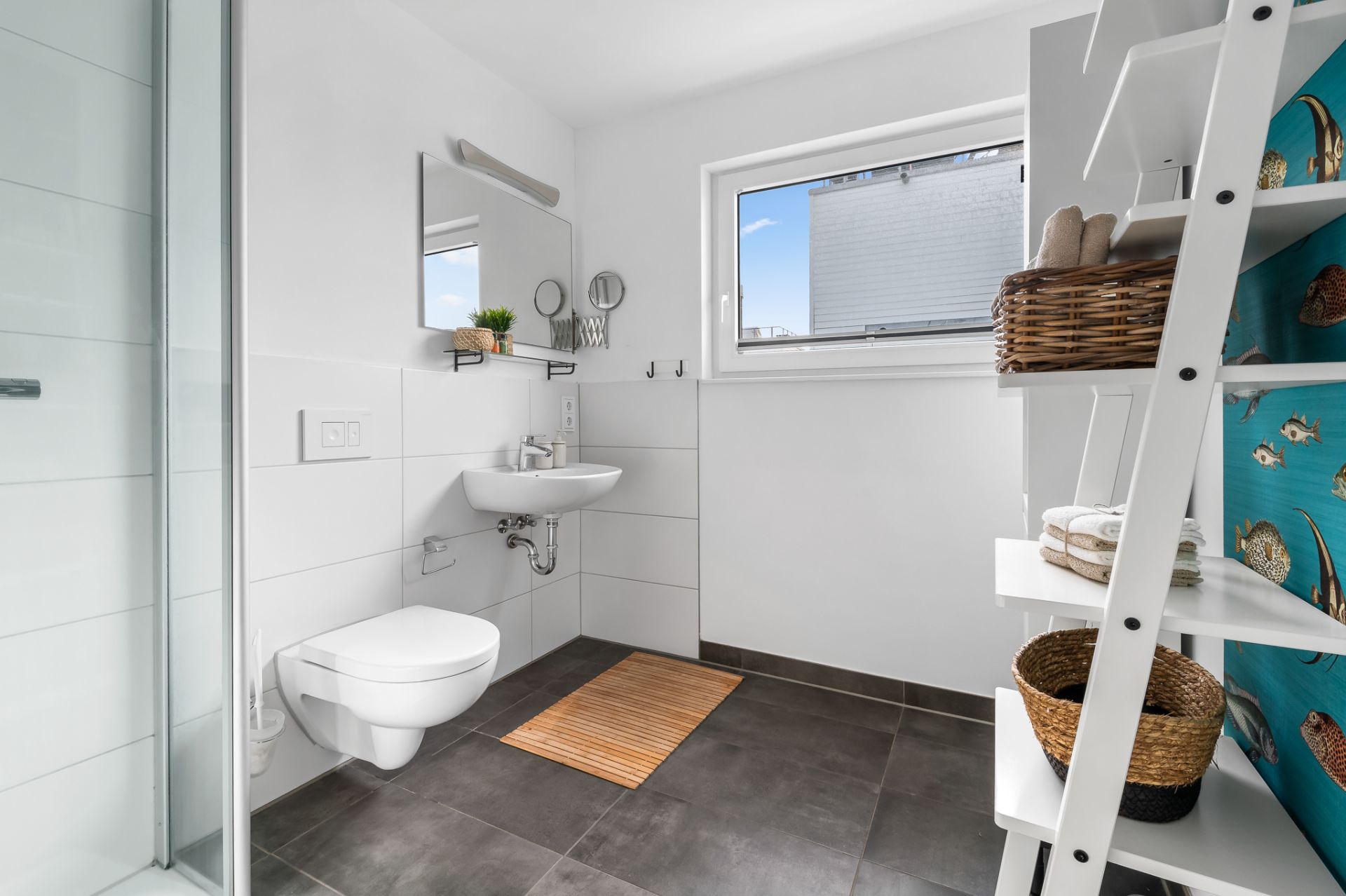 Modernes Badezimmer mit Dusche, Wand-WC, Waschbecken, Regal und Fenster.
