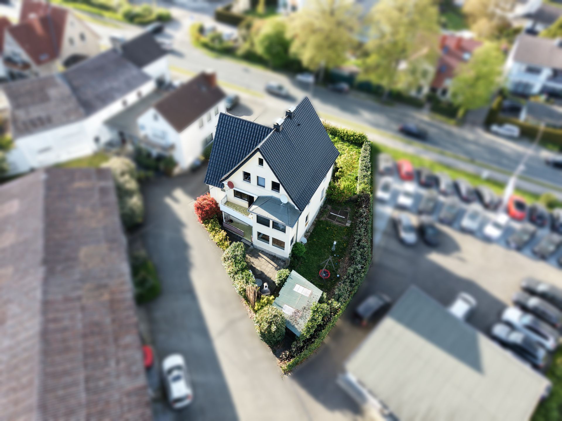 Luftaufnahme eines Einfamilienhauses mit Garten und angrenzenden Gebäuden.