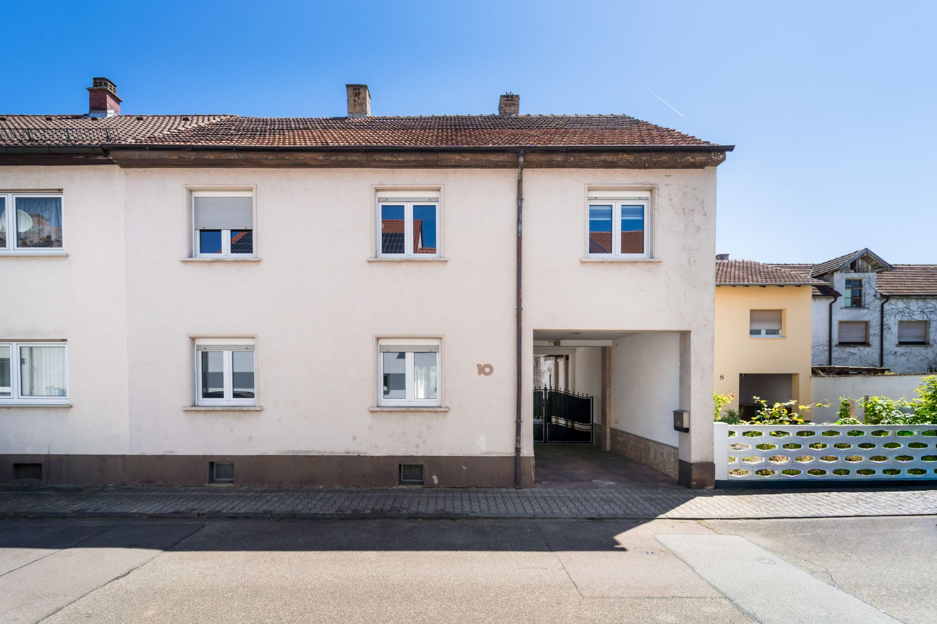 Zweistöckiges Wohnhaus mit Durchfahrt und mehreren Fenstern an der Straßenseite.