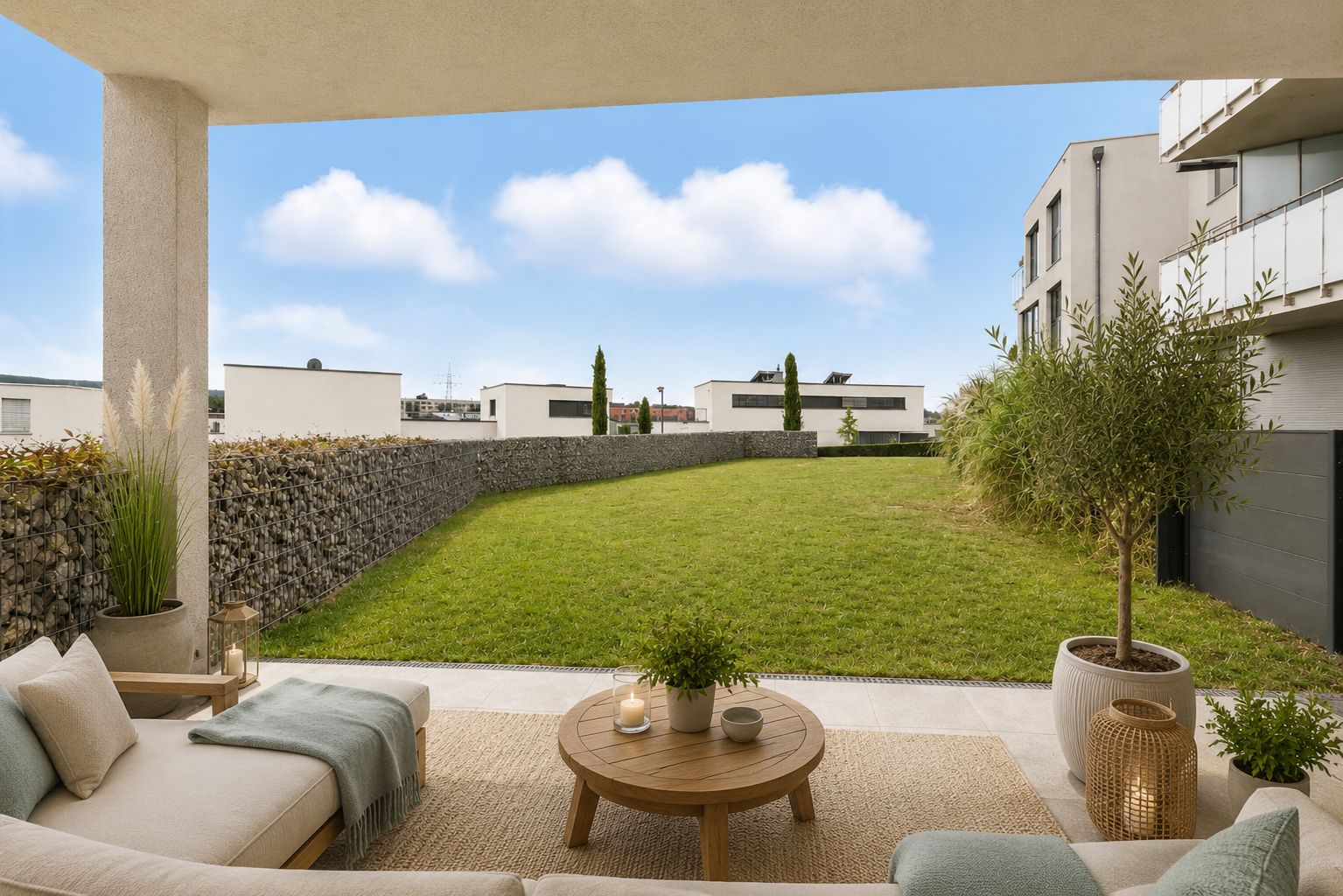 Überdachte Terrasse mit Sofa und Tisch, Blick auf großen gepflegten Garten und moderne Wohnhäuser.