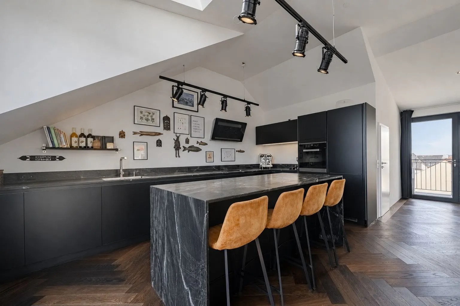 Moderne schwarze Küche mit Kochinsel, vier Barhockern und Dekoration an der Wand.