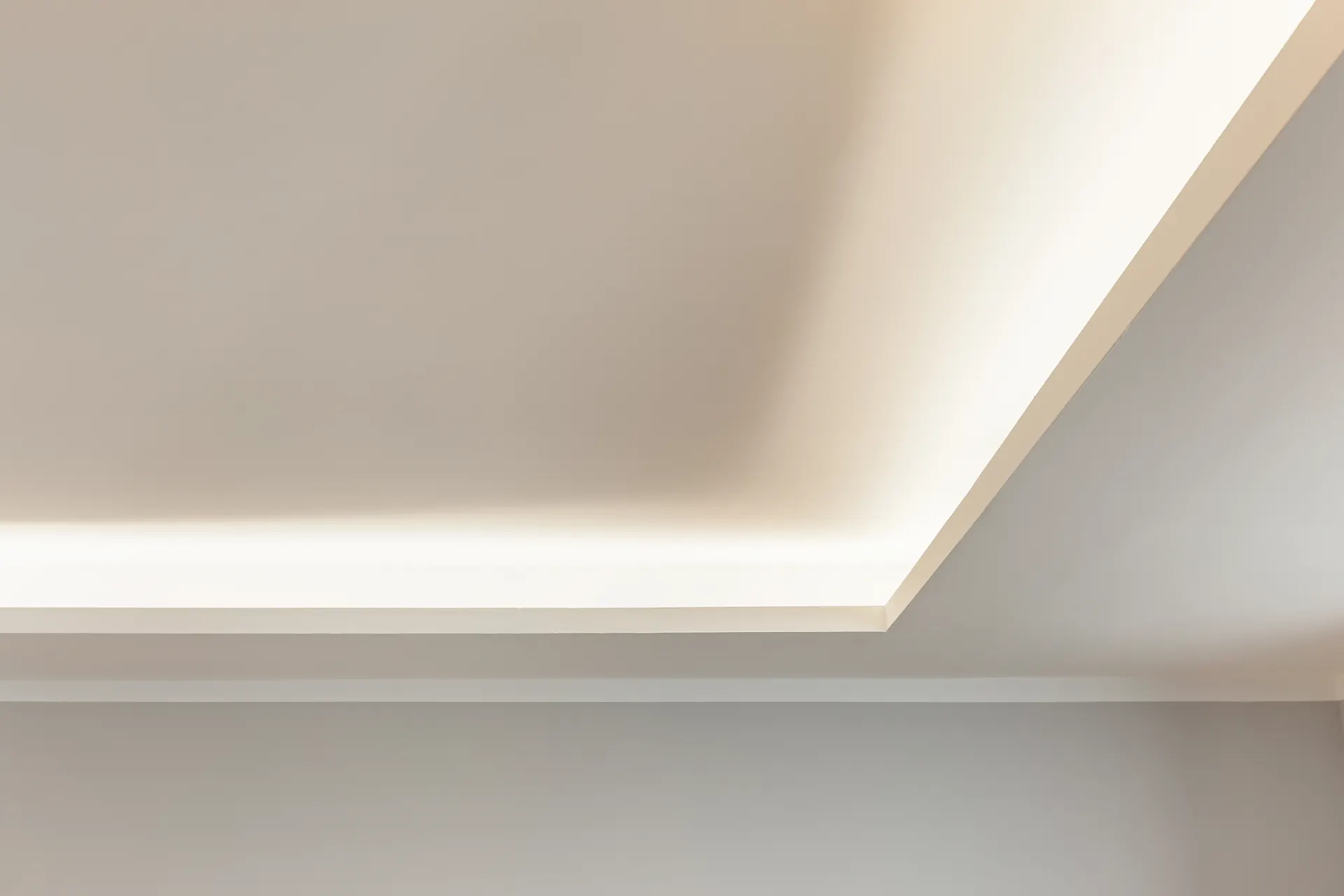 Abgehängte Decke mit indirekter Beleuchtung in einem Raum.