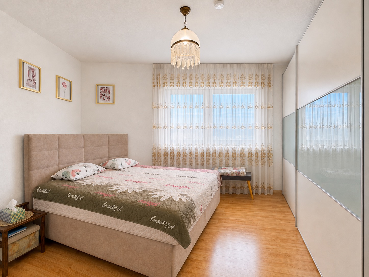 Helles Schlafzimmer mit Doppelbett, Nachttisch, großem Fenster und Einbauschrank.