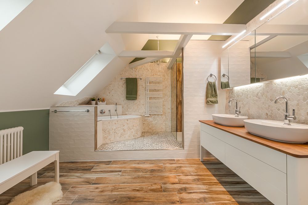 Modernes Badezimmer mit zwei Waschbecken, großer Dusche und Badewanne unter einem Dachfenster.