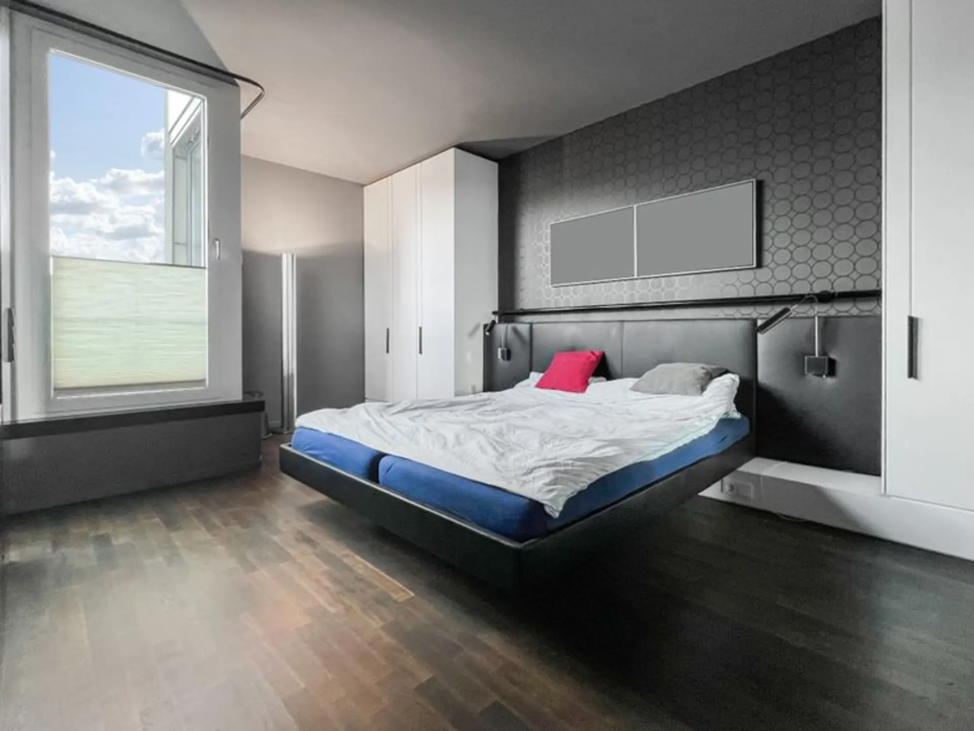 Modernes Schlafzimmer mit Doppelbett, zwei weißen Schränken und großem Fenster.