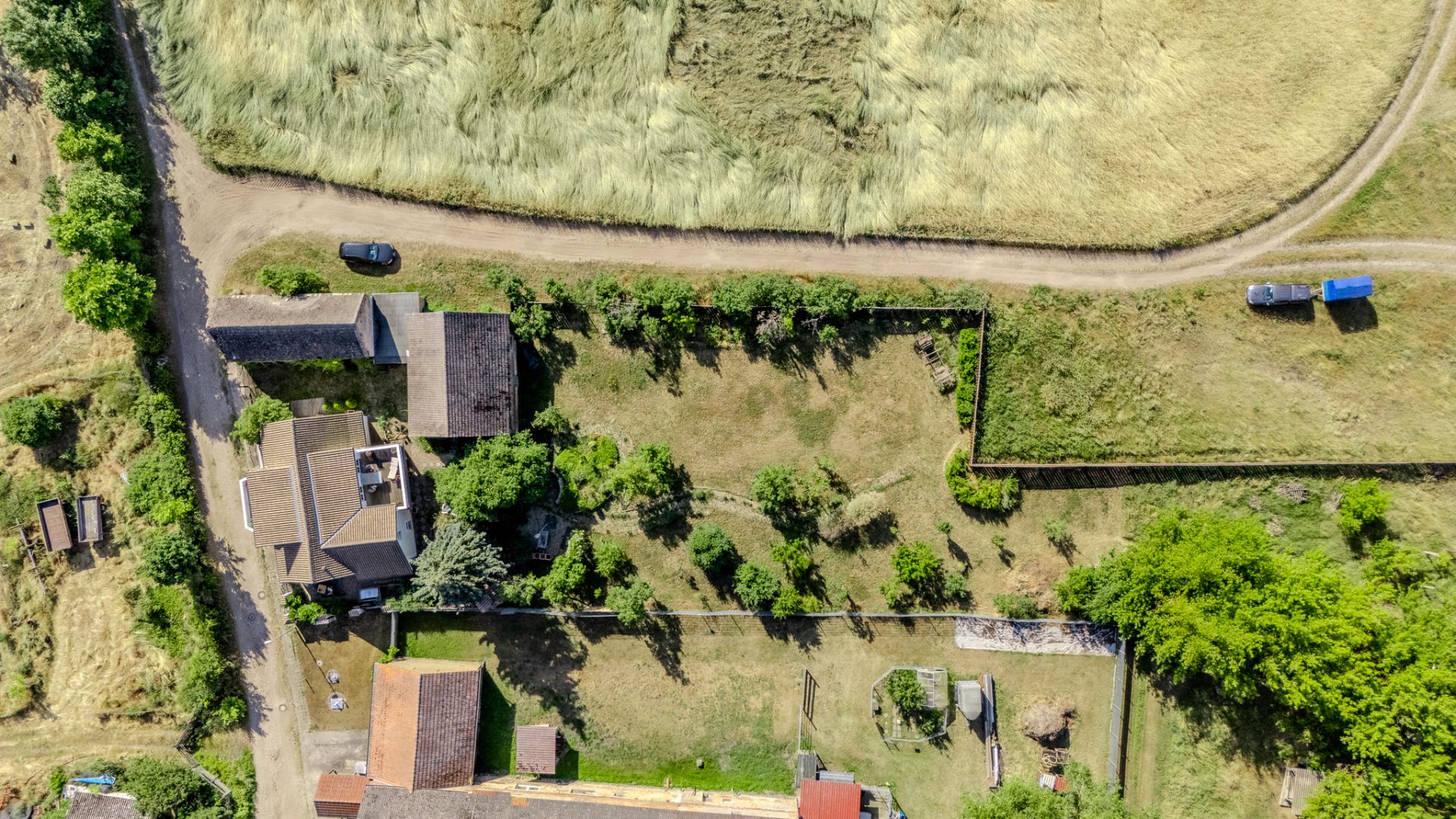 Luftaufnahme eines Wohnhauses mit Garten und umliegenden Feldern.