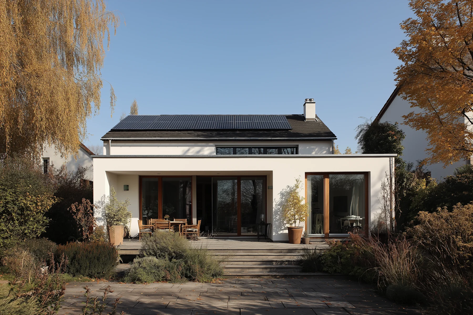 Große Photovoltaikanlage mit Solarpanelen auf einer grünen Wiese unter blauem Himmel.