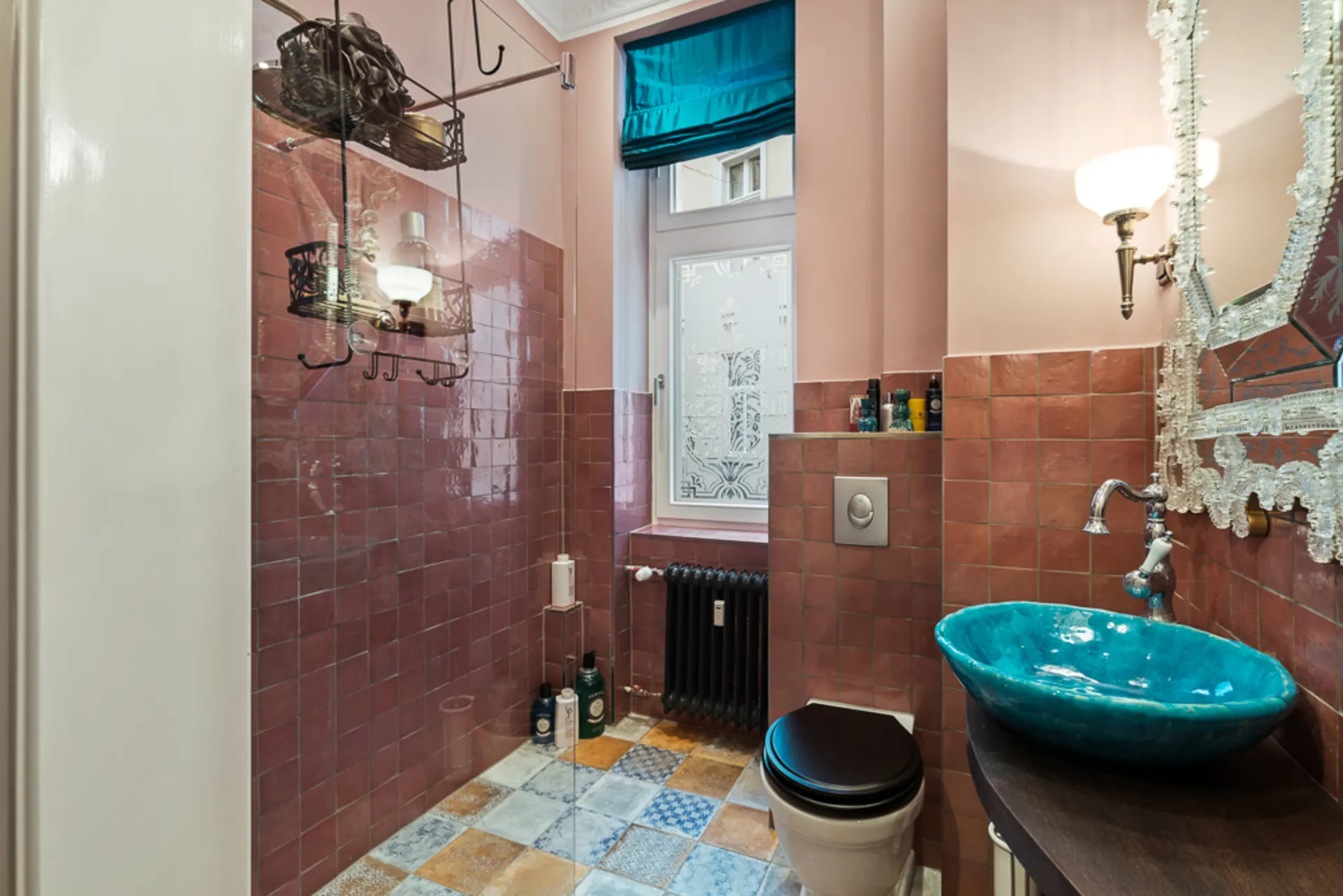 Badezimmer mit rosa Fliesen, Duschbereich, türkisfarbenem Waschbecken und Fenster mit Vorhang.