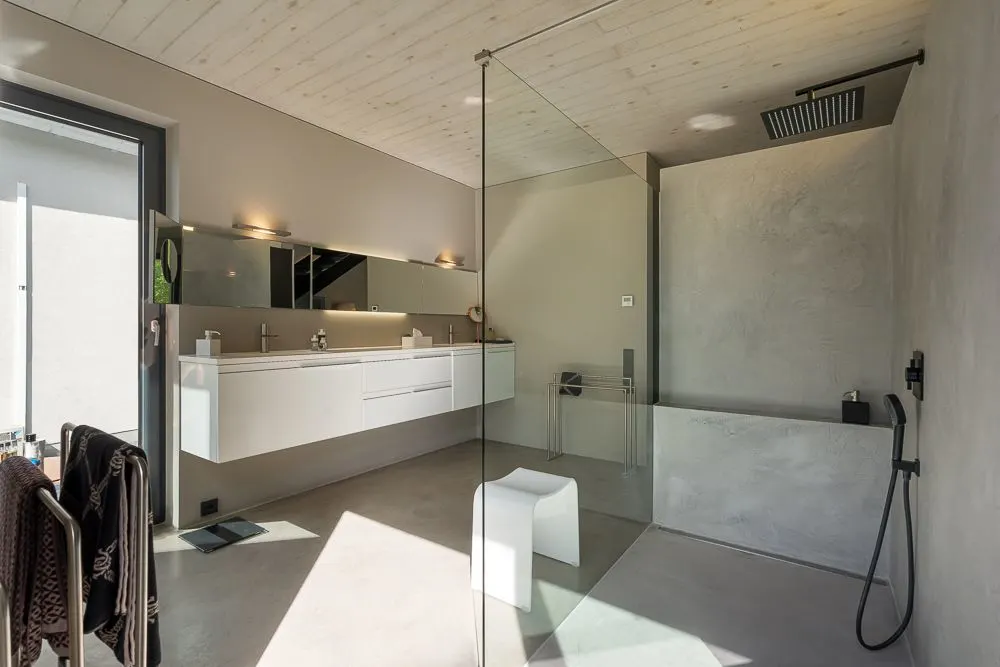Modernes Badezimmer mit ebenerdiger Dusche, Doppelwaschbecken und großem Spiegel.