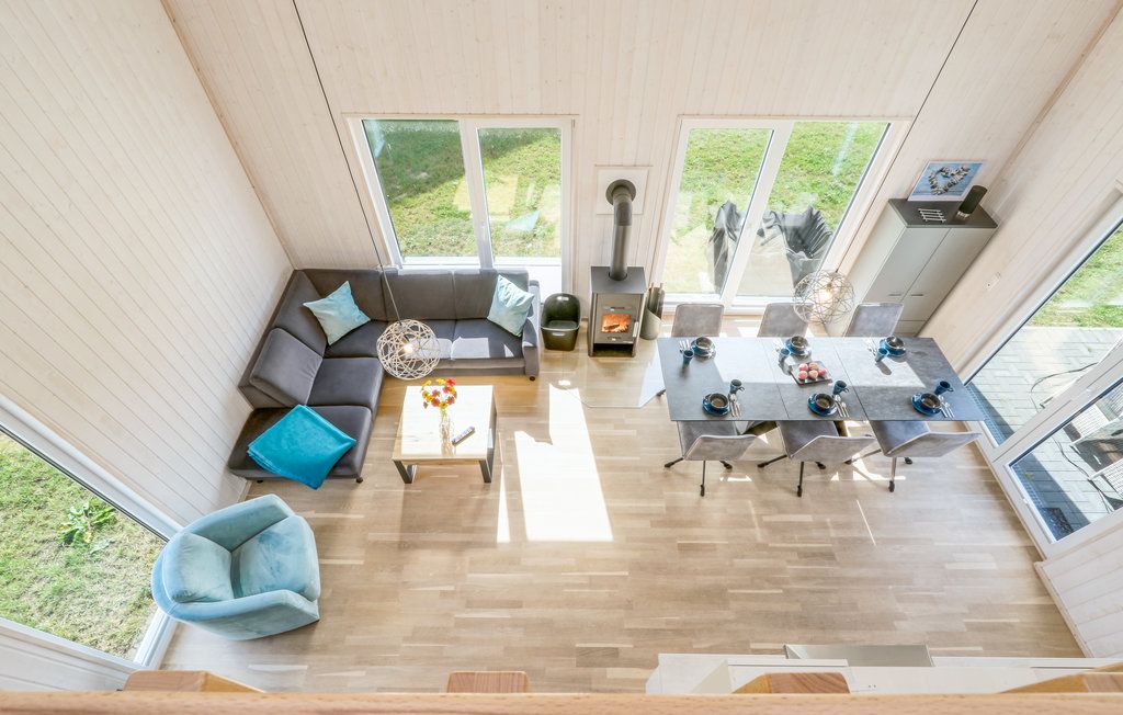 Wohnzimmer mit Ecksofa, Sessel, Esstisch für sechs Personen und Kamin, aus der Vogelperspektive.
