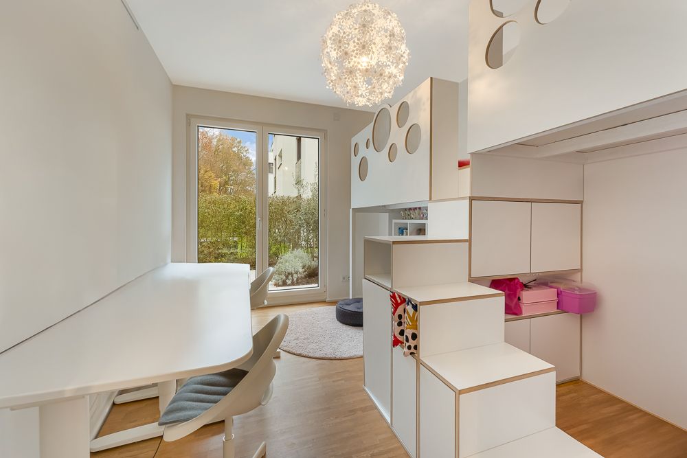 Modernes Kinderzimmer mit Hochbett, Schreibtisch und großem Fenster zur Terrasse.