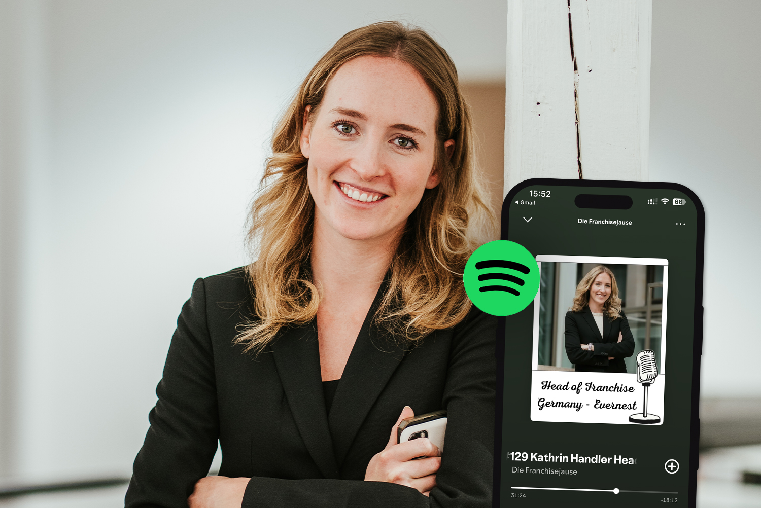 Frau mit langen blonden Haaren im schwarzen Blazer steht neben einem Smartphone mit Spotify-App.