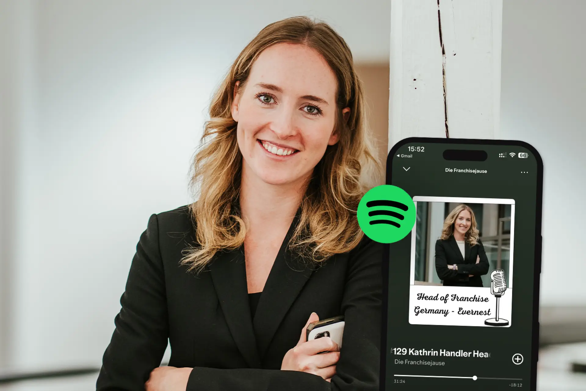 Frau mit langen blonden Haaren im schwarzen Blazer steht neben einem Smartphone mit Spotify-App.