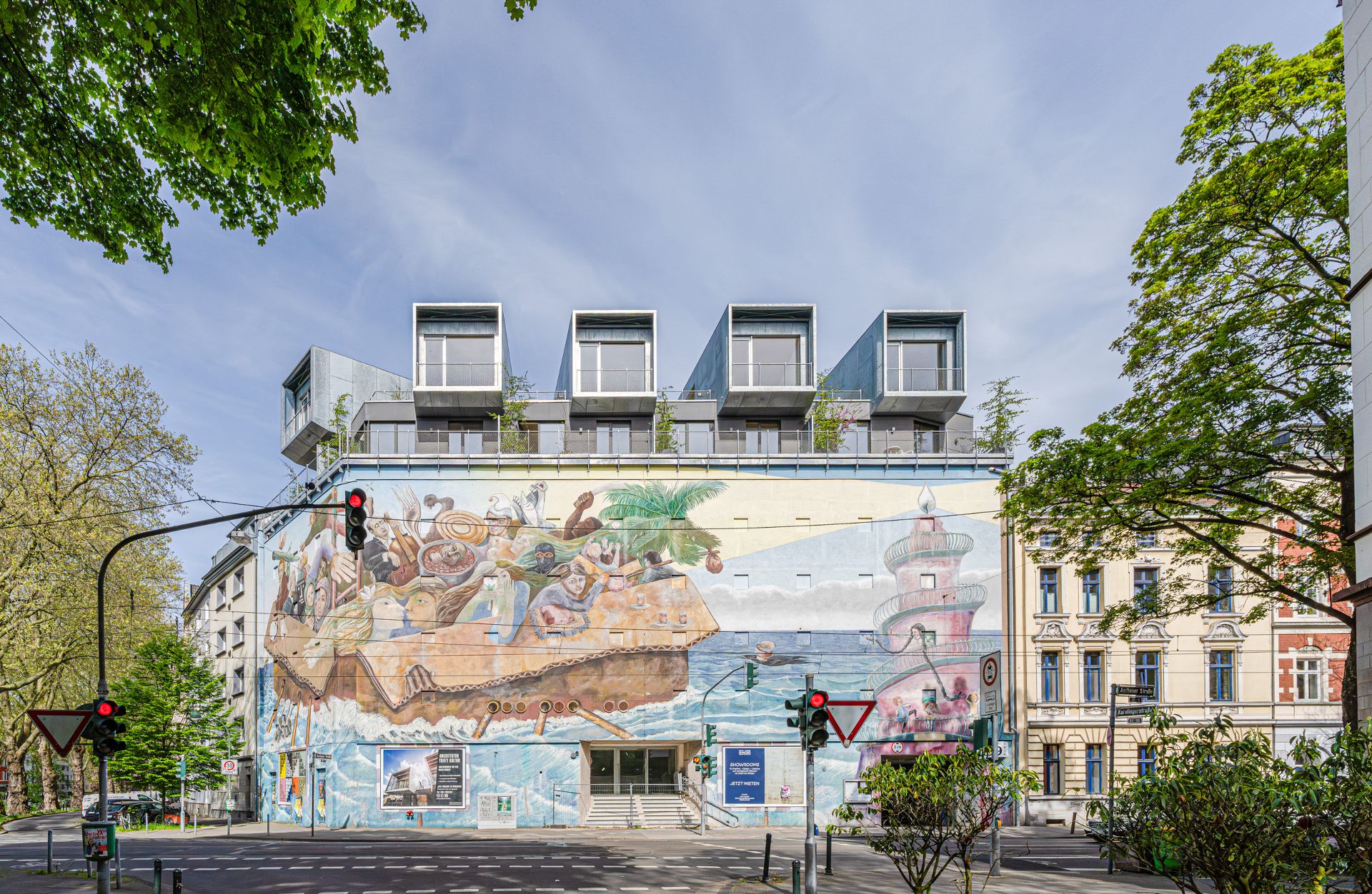 Wohngebäude mit großen Fenstern und einer bunten Wandmalerei an der Fassade.