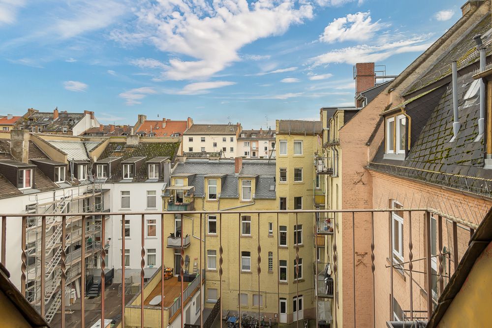Blick von einem Balkon auf mehrere Wohngebäude mit vielen Fenstern und Balkonen.