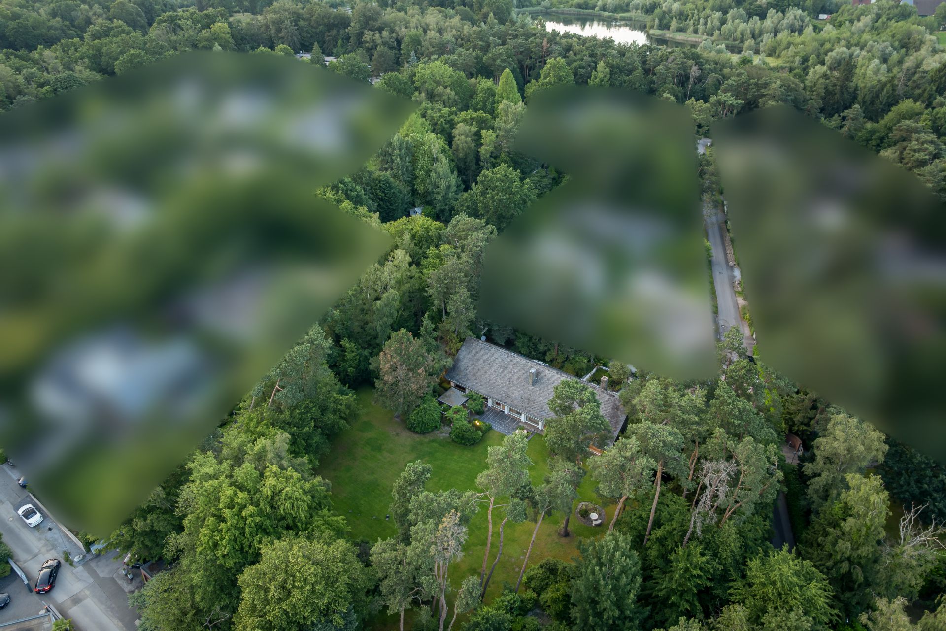 Luftaufnahme eines Hauses mit großem Garten, umgeben von vielen Bäumen.