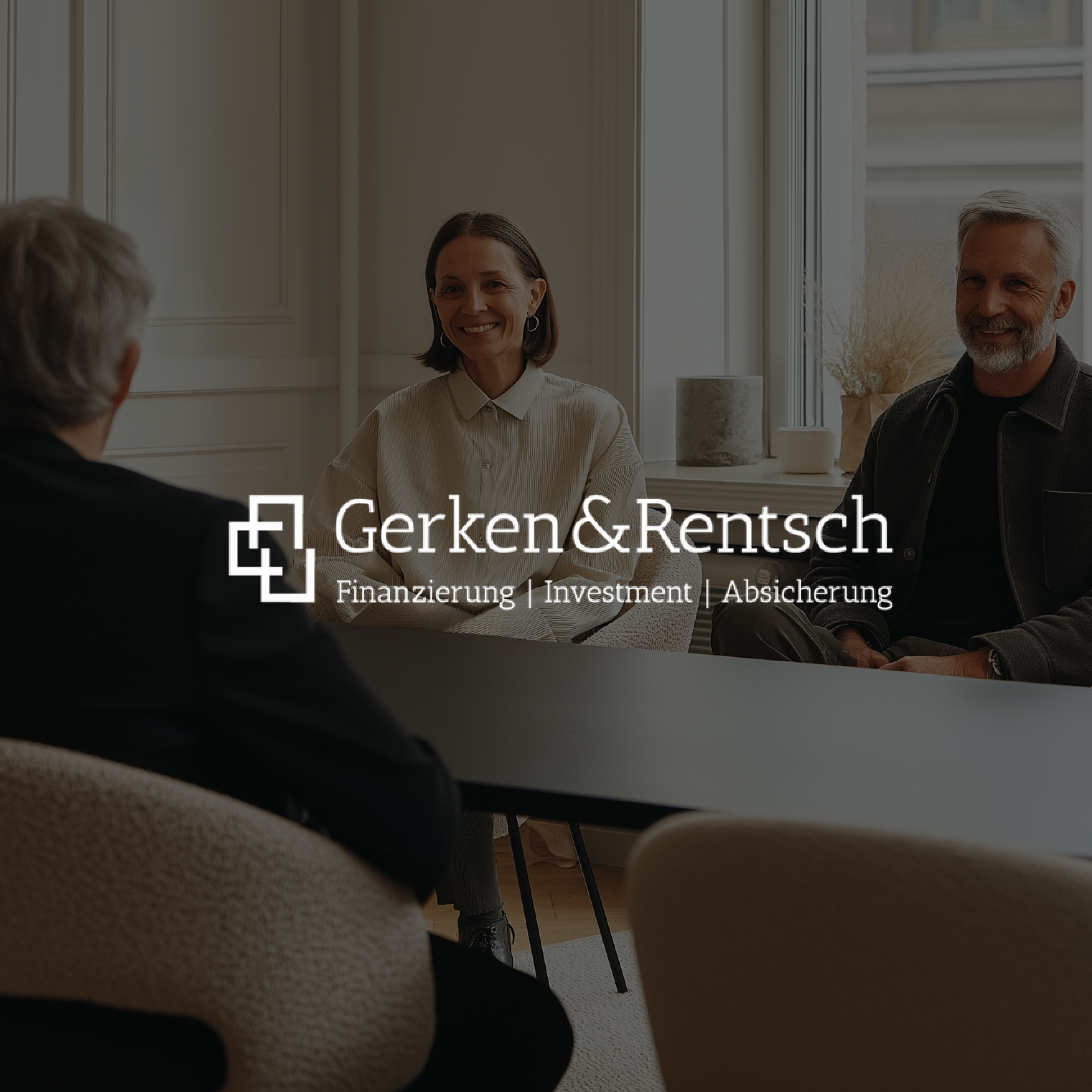 Drei Personen sitzen an einem Tisch in einem hellen Raum mit großen Fenstern.