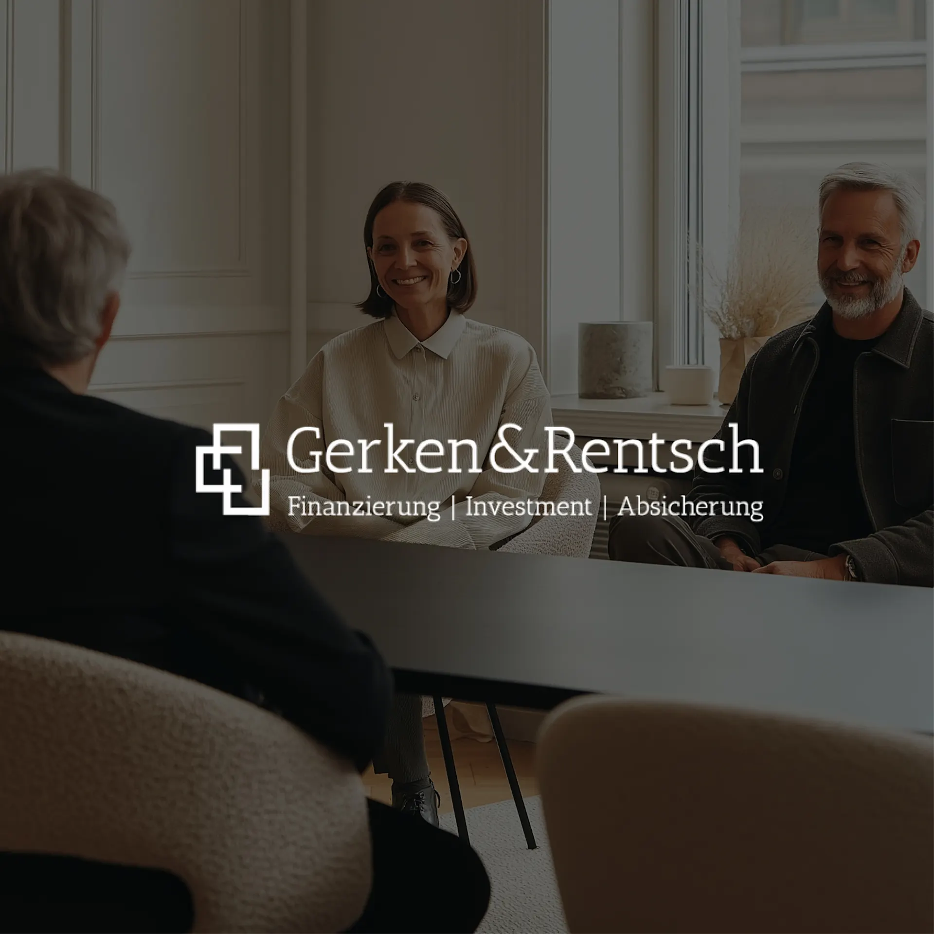 Drei Personen sitzen an einem Tisch in einem hellen Raum mit großen Fenstern.