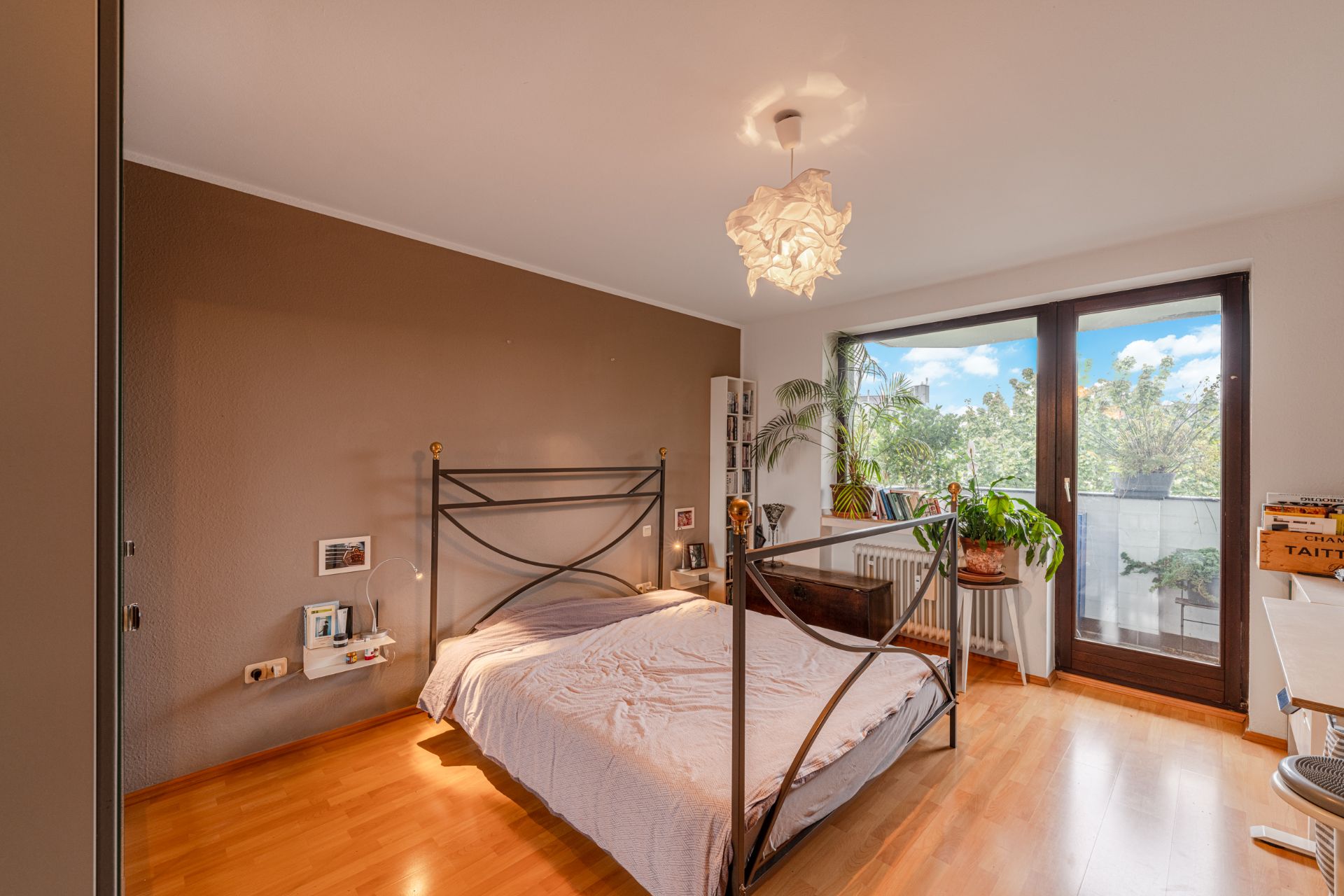 Helles Schlafzimmer mit Doppelbett, Pflanzen und Zugang zu einem Balkon mit Aussicht.