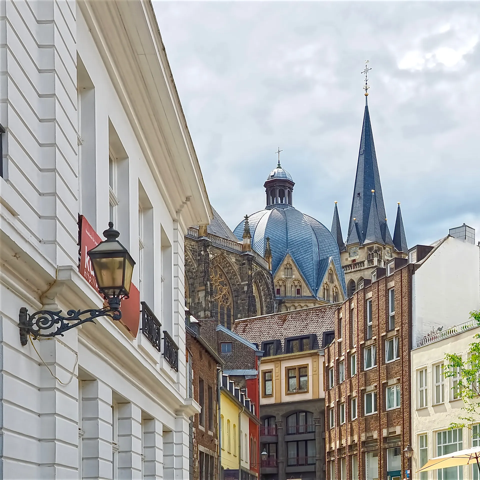 Blick auf Wohngebäude und eine Kirche mit Kuppel und Turm im Hintergrund.