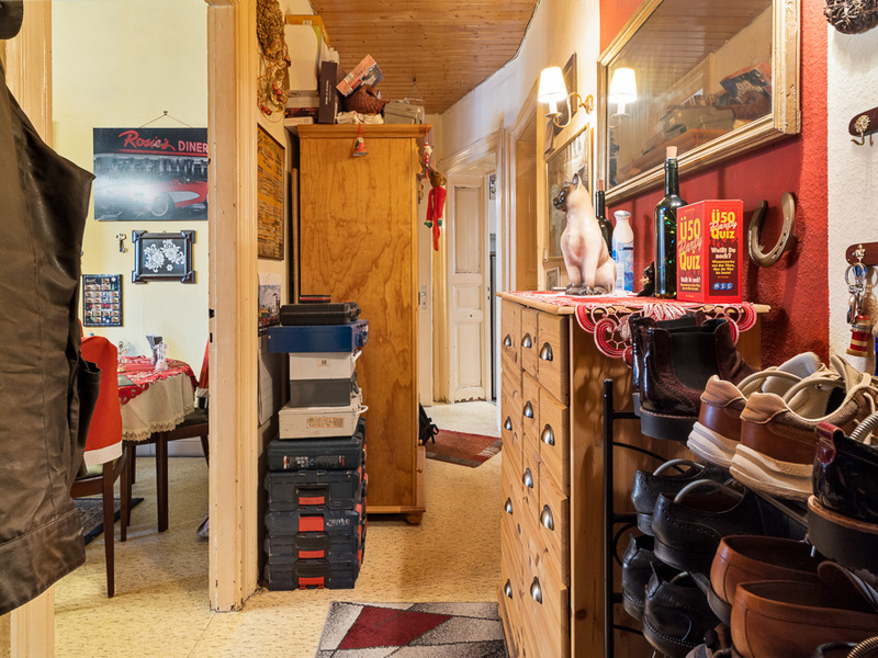 Flur mit Kommode, Schuhregal, Spiegel und Blick ins Esszimmer mit Tisch und Stühlen.