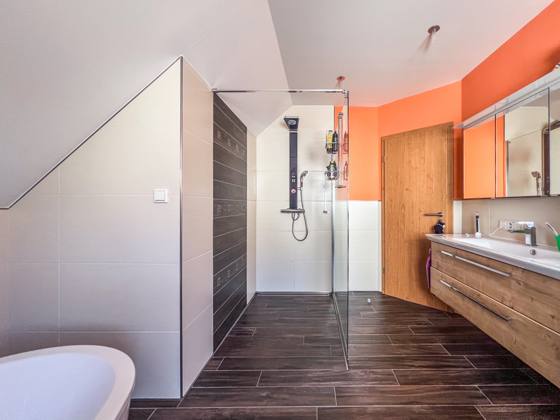 Modernes Badezimmer mit Glasduschkabine, Badewanne und Holzwaschtisch.