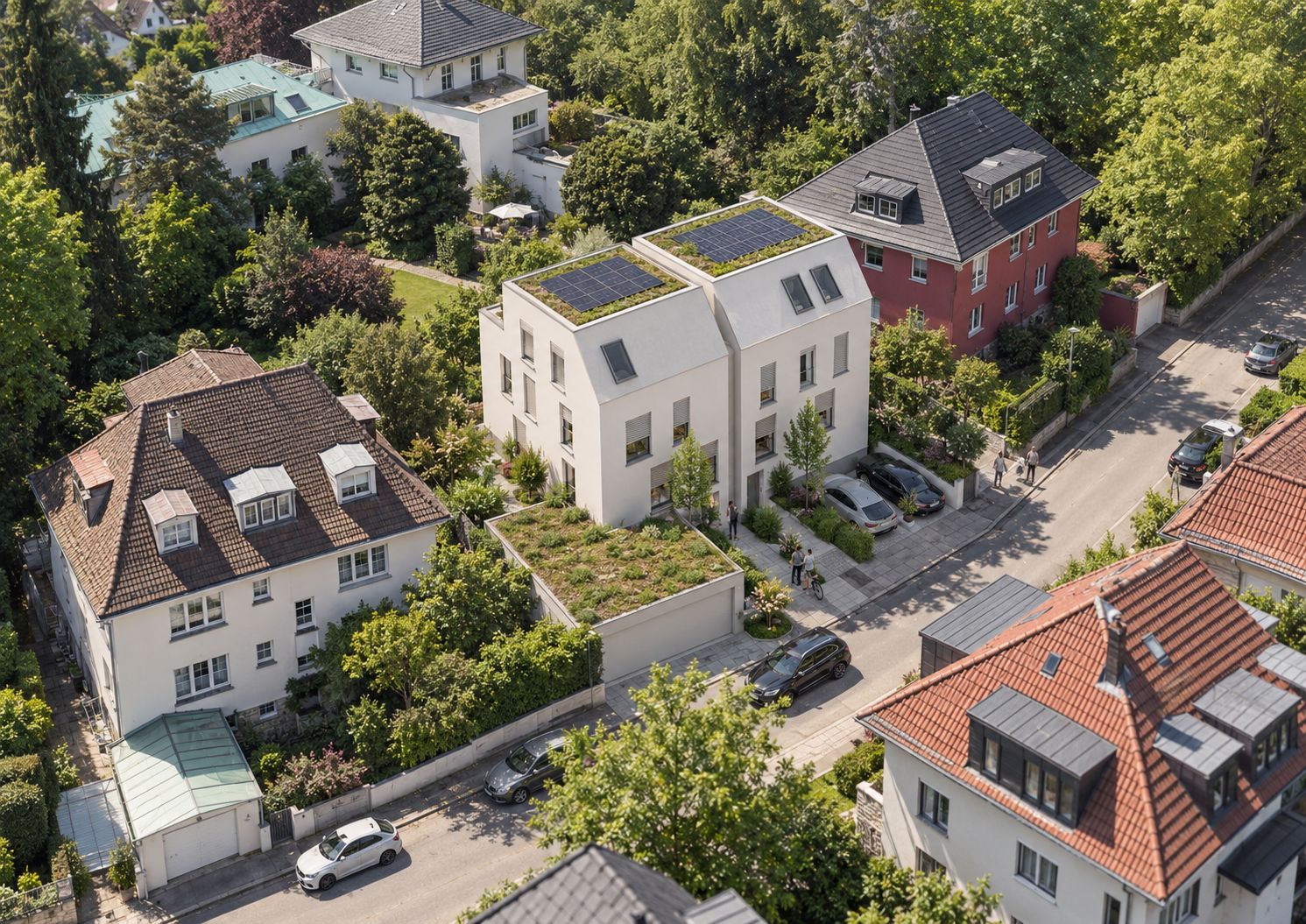 Luftaufnahme von Wohnhäusern in einem grünen Wohnviertel, einige Dächer mit Solarpaneelen.