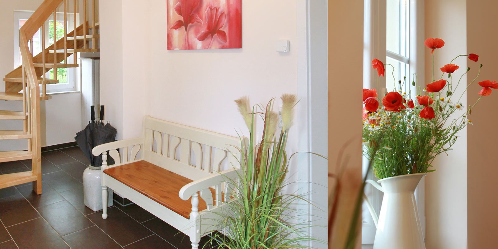 Flur mit Holztreppe, weißer Bank, Pflanzen und Bild mit roten Blumen an der Wand.