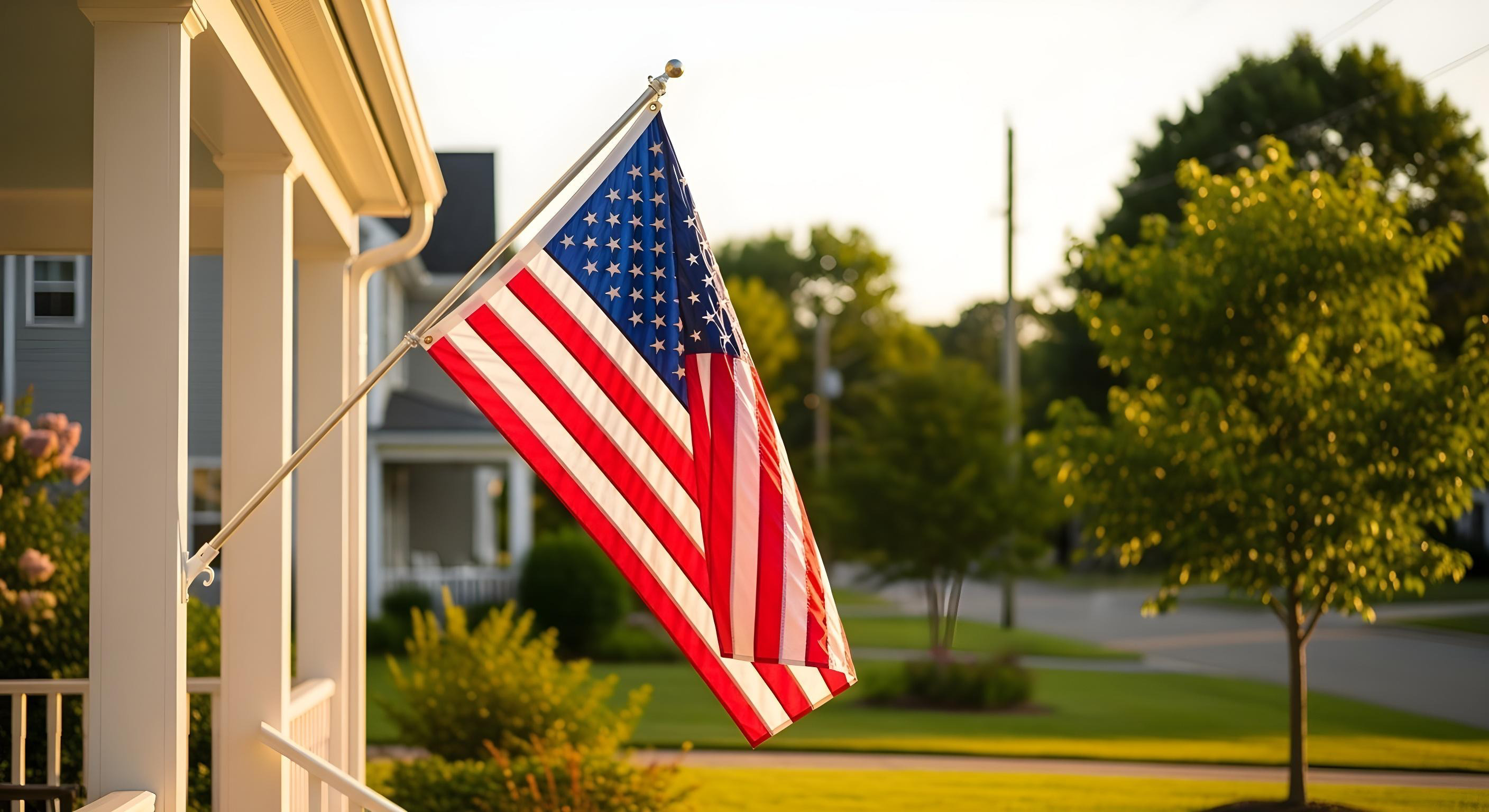US-Flagge hängt an der Veranda eines weißen Wohnhauses.