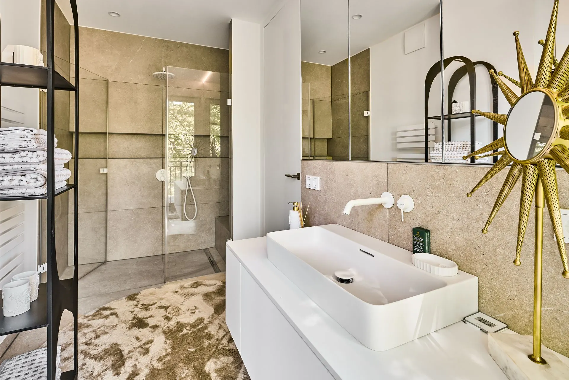 Modernes Badezimmer mit großem Spiegel, Waschbecken, offener Dusche und Regal mit Handtüchern.
