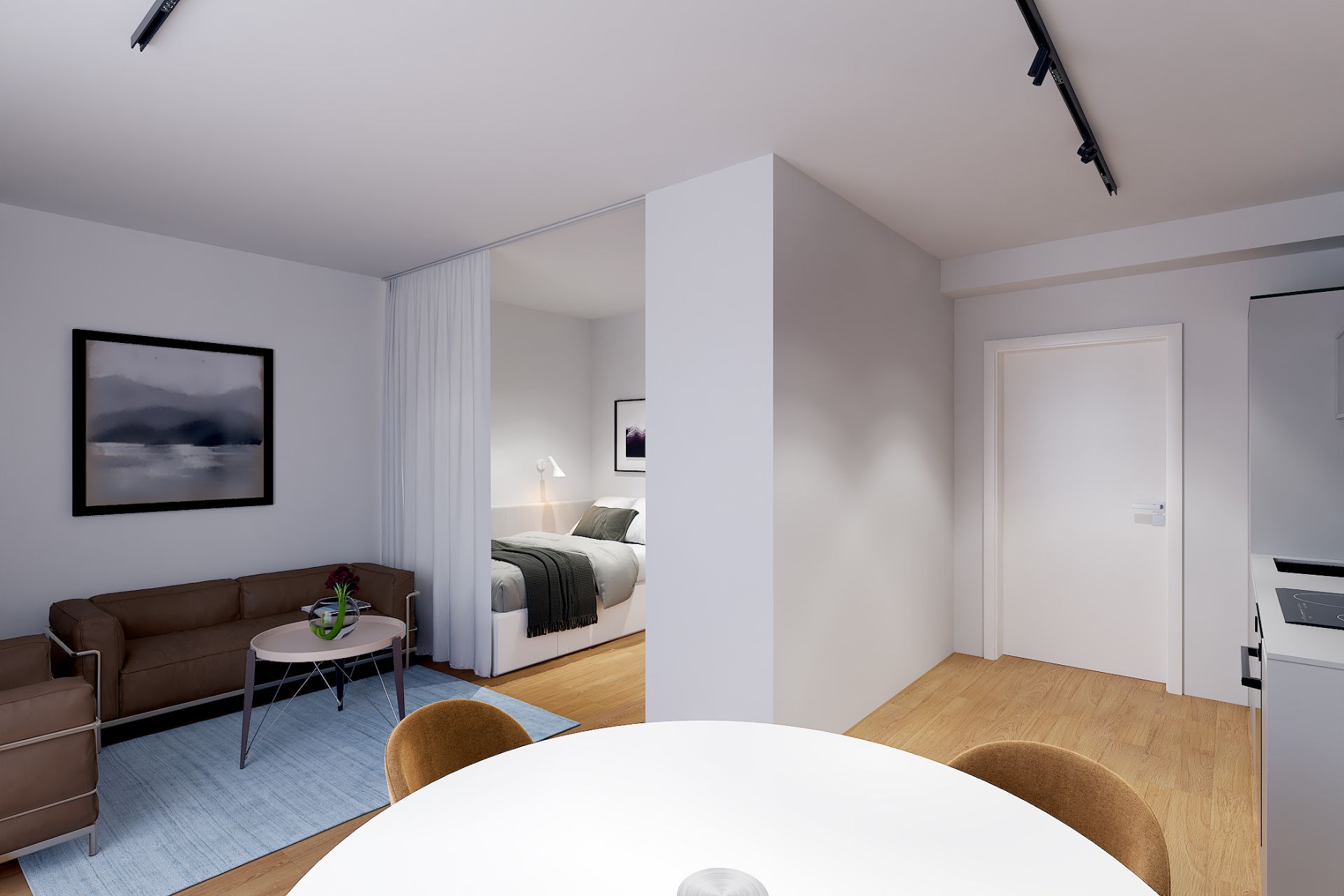 Wohnzimmer mit Sofa, Sessel und Blick ins Schlafzimmer, Holzboden und runde Esstischkante sichtbar.
