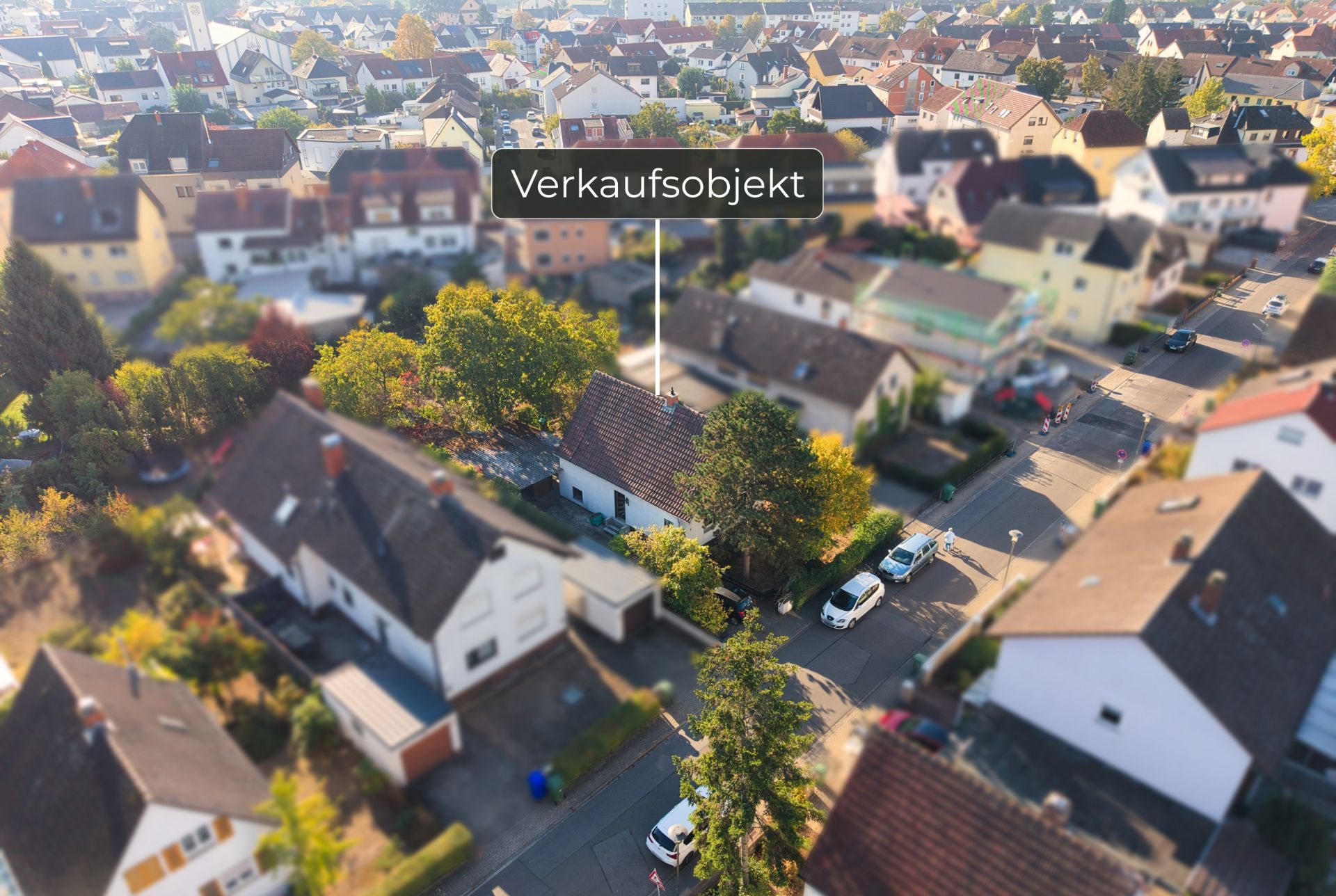 Luftaufnahme eines Wohnhauses in einem Wohngebiet, mit Hinweis auf ein Verkaufsobjekt.